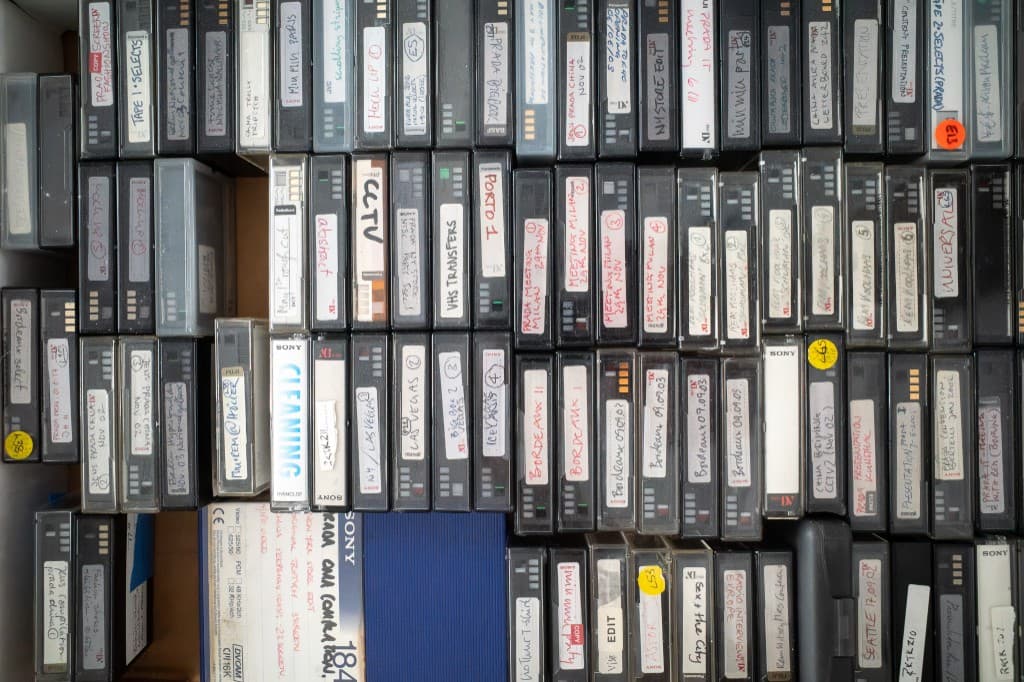 The physical MiniDV and DVCAM archive, tapes packed in a drawer with handwritten labels.